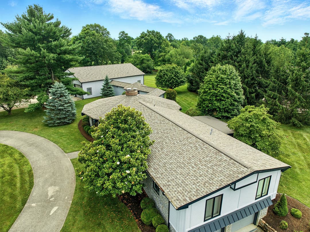 Aerial view of a modern home surrounded by lush greenery and landscaped gardens.